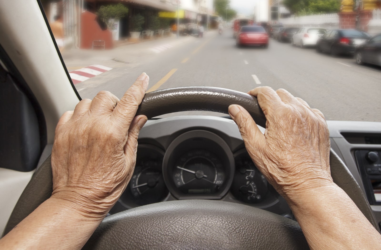 A first-person view of an older person driving a car