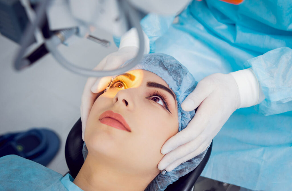 A female patient is lying on an eye operating table, the patient is undergoing a laser procedure posterior capsulotomy which allows light to fill it again for clear vision.